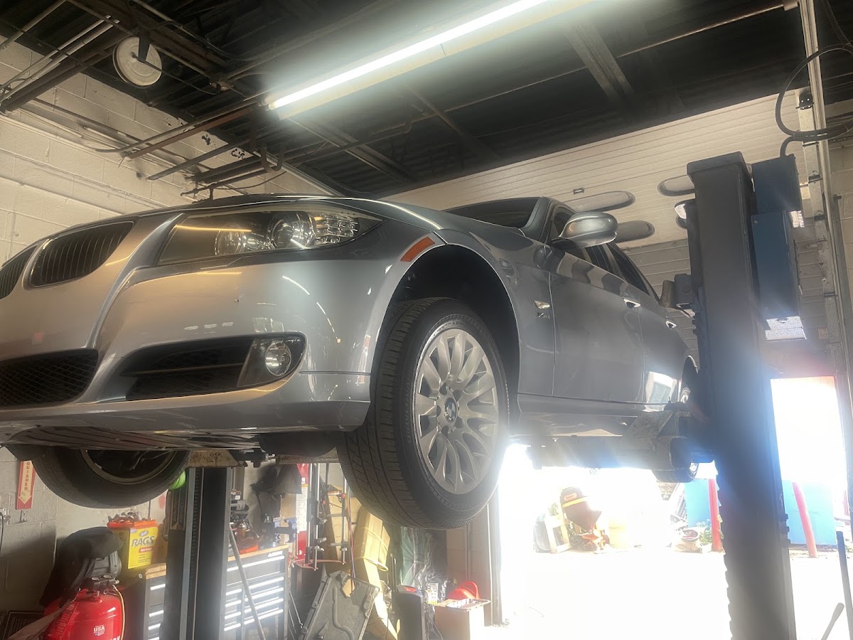 A BMW 3 Series raised on a two-post lift for service