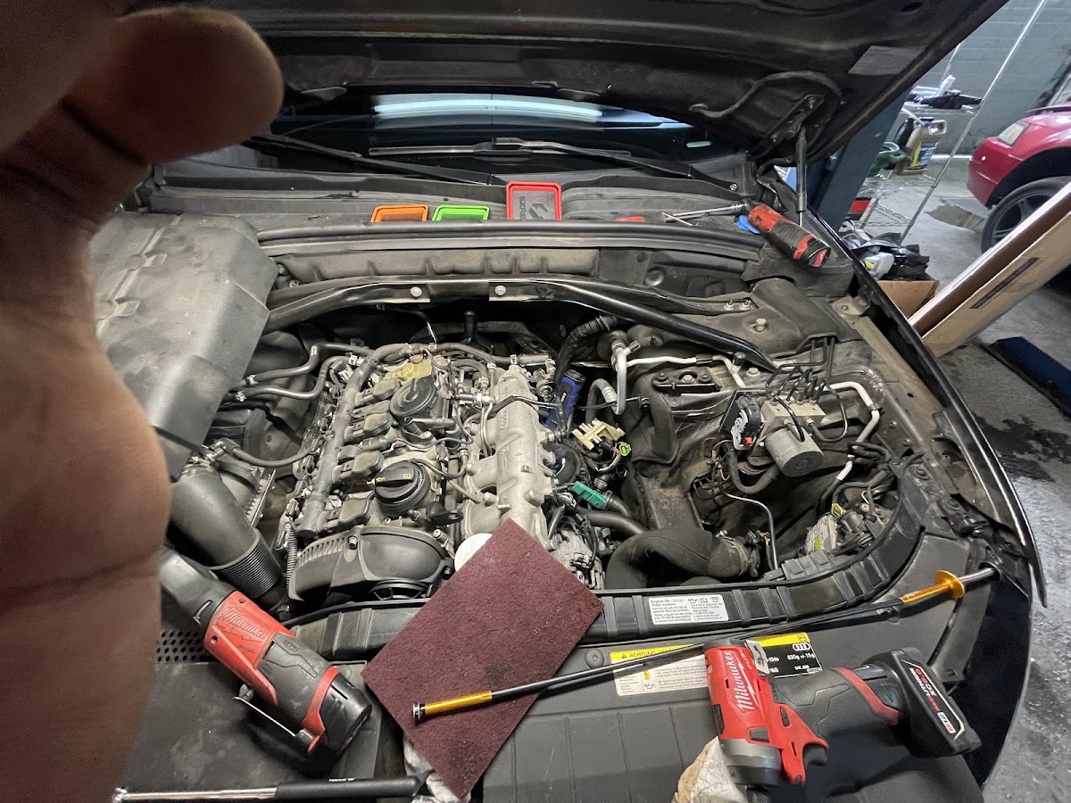 A mechanic working under the hood on an engine repair