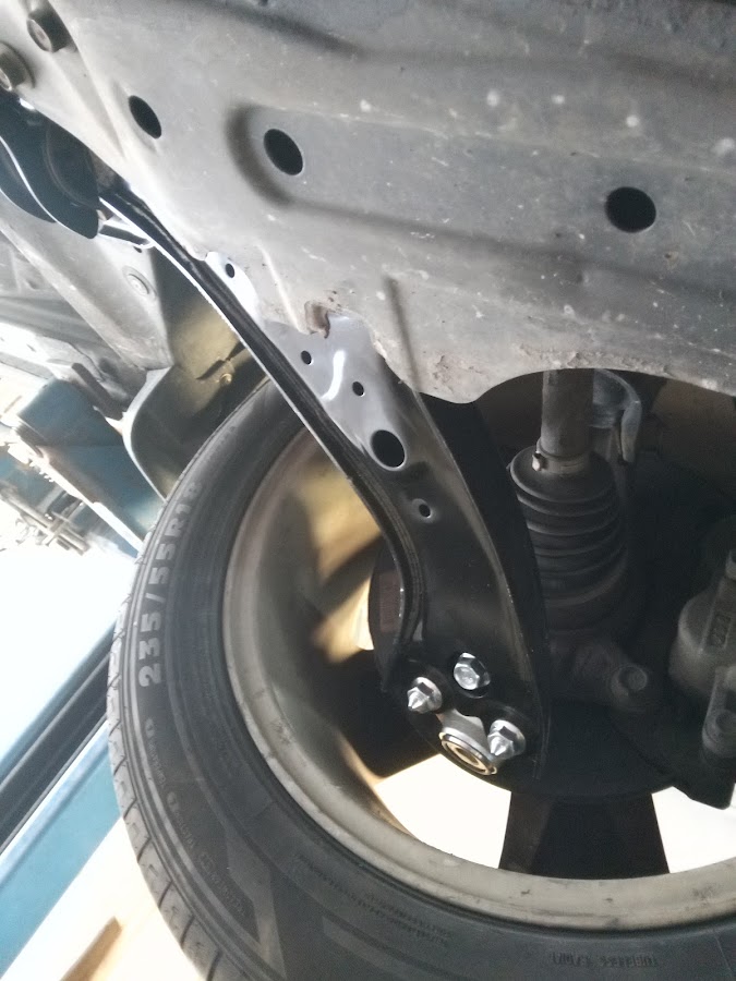A close-up of suspension and control-arm repair work